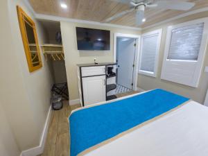 Un dormitorio con una cama con una manta azul. en Seashell Motel, en Key West