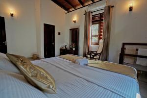 a bedroom with a large bed with white sheets at Golden Gate in Galle
