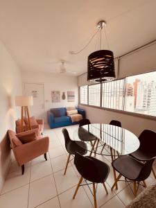 a living room with a table and chairs and a couch at AP localização é tudo Pitangueiras in Guarujá