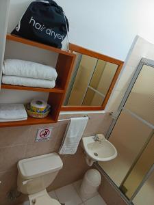 a bathroom with a toilet and a sink and a mirror at Teresita's House - Suites con cocina privada in Puerto Baquerizo Moreno +53 photos