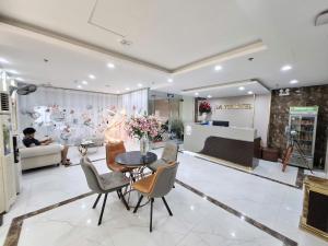 a lobby with a table and chairs and a person at Lavie Hotel in Hanoi