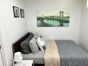 a bedroom with a bed and a painting on the wall at Cozy & private apartment outside the city center in Hampstead