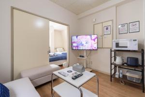 a living room with a couch and a tv at アンドステイ永福3丁目202 in Tokyo