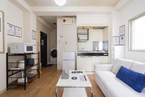 a living room with a white couch and a table at アンドステイ永福3丁目202 in Tokyo