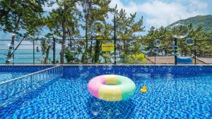 una piscina con una pelota inflable en el agua en Yeosu Sea&Blue Family Pension, en Yeosu