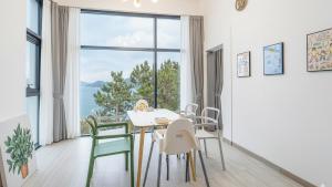Un comedor con mesa y sillas y una gran ventana. en Yeosu Sea&Blue Family Pension, en Yeosu 8 fotos más
