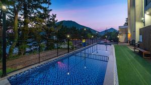 una piscina con vistas a las montañas en Yeosu Sea&Blue Family Pension, en Yeosu