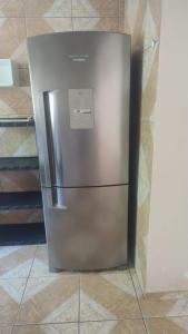 a stainless steel refrigerator sitting on a tile floor at Casa 6 in Olinda