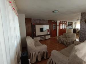 プーノにあるDepartamento entero en Punoのリビングルーム(椅子、薄型テレビ付)