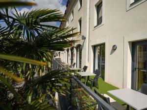 un balcón con mesas y sillas junto a un edificio en Ibis Vitré Centre, en Vitré