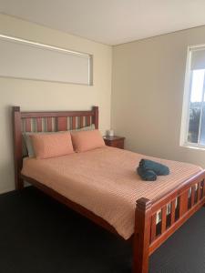 a bedroom with a bed with a hat on it at Platinum Apartments at Bargara in Bargara +17 photos