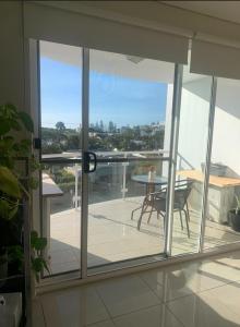 a room with a balcony with a table and a view at Platinum Apartments at Bargara in Bargara