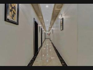 a hallway with white walls and a tile floor at Hotel O Raas Near Peera garhi Metro Station in New Delhi