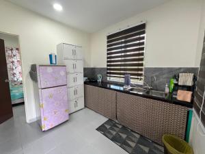 a kitchen with a refrigerator and a sink at Homestay Teratak Ainaz in Alor Setar