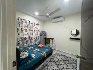 a bedroom with a bed and a ceiling fan at Homestay Teratak Ainaz in Alor Setar
