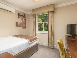 a bedroom with a bed and a window at Mercure Salisbury White Hart Hotel & Apartments in Salisbury +140 photos