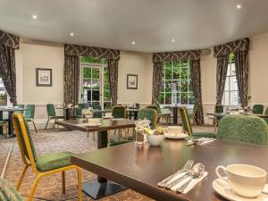 a restaurant with tables and chairs and windows at Mercure Salisbury White Hart Hotel & Apartments in Salisbury
