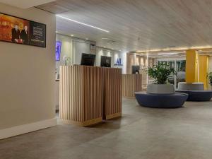 a lobby with wooden dividers and potted plants at Mercure Maceio Pajuçara in Maceió
