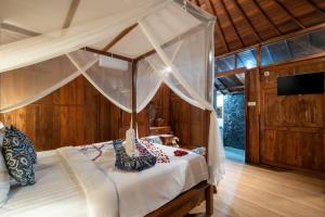 a bedroom with a bed with a canopy at Anggi Villas Ubud in Tegalalang