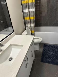 a bathroom with a sink and a toilet and a shower at Bedroom in the basement Upland 2 in Edmonton