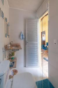 a bathroom with a toilet and a glass shower door at Casa Aconchegante 500m Praia de Setiba- Guarapari ES, Wi-fi, enxoval completo, lugar tranquilo para grupo de famílias, amigos, pets in Guarapari