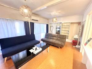 a living room with a couch and a table at ハレアカラ - 4階建てプライベートマンション in Asato +35 photos