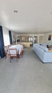 una sala de estar con un sofá y una mesa en Scenic Coastal Gem with Pool, Tennis, Securely Gated, en Whangaparaoa