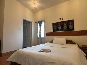 a bedroom with a large white bed with a window at Homestay Bentre Coco Lodge in Ben Tre