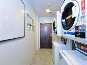 a hospital room with a washing machine and a door at HOTEL MYSTAYS Fukuoka Tenjin Minami in Fukuoka