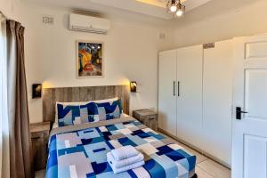 a bedroom with a bed with blue and white pillows at Rembrandt in Ballito