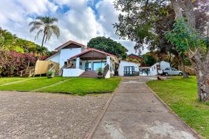 a white house with a palm tree and a driveway at Rembrandt in Ballito