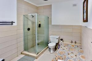 a bathroom with a toilet and a glass shower at Rembrandt in Ballito