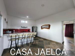 a kitchen with a bar with stools in a room at spacious apartment with ocean view in Brisas de Zicatela