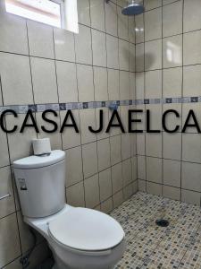 a bathroom with a toilet and a sign on the wall at spacious apartment with ocean view in Brisas de Zicatela