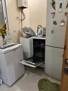 a kitchen with a refrigerator and an open oven at Résidences tazerzit smouna in Agadir +2 photos