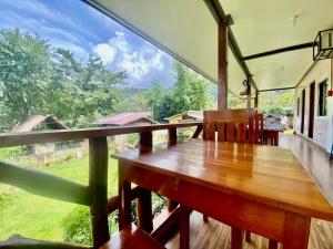 a wooden table and chairs on a balcony with a view at Mariah Guest House in Port Barton