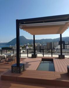 a pavilion with a pool on top of a building at BEPPU Sento in Beppu