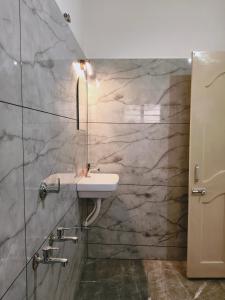 a bathroom with a sink and a mirror at Aromal Homestay in Kovalam