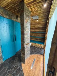 a bathroom with a stone shower with blue walls at Kenanga Bamboo Villa in Dinalupihan