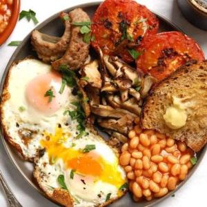 a plate of breakfast food with eggs bacon beans and toast at Beyond borders boutique hotel in Polokwane