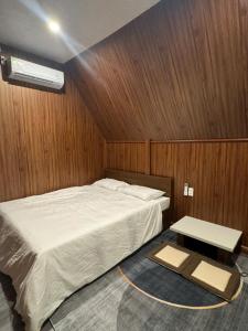 Hồ Bình Yên Homestay&Coffee-BBQ في Plei Kơtêng: غرفة نوم بسرير ابيض وطاولة