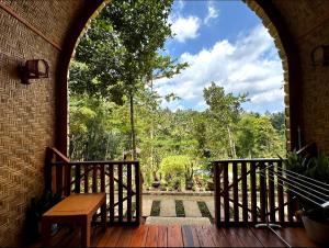 an arched entry way to a porch with a bench at Tetebatu flower in Tetebatu