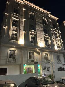 a white building with cars parked in front of it at أجنحة المدينة للشقق المفروشة in Al Madinah +133 photos