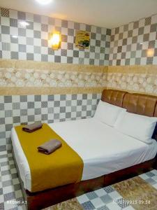 a bedroom with a bed with two towels on it at Silver Sky hotel in Kuala Lumpur