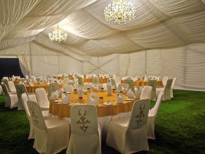 a large tent with tables and chairs and chandeliers at Sofitel Bahrain Zallaq Thalassa Sea & Spa in Manama +208 photos