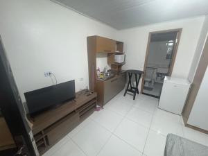 a living room with a flat screen tv and a kitchen at kitnet in Colombo +9 photos