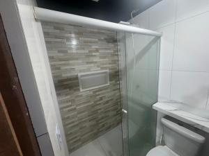 a bathroom with a glass shower with a toilet at kitnet in Colombo