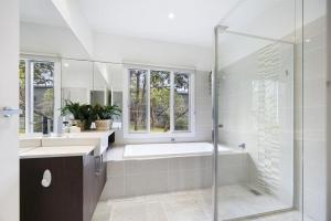a bathroom with a tub and a glass shower at Nautilus Rise – Panoramic Bay Coastal Views in Tootgarook +17 photos