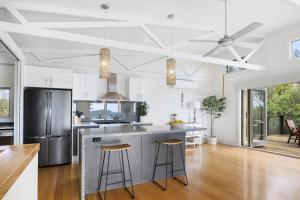 a kitchen with a large island with bar stools at Nautilus Rise – Panoramic Bay Coastal Views in Tootgarook