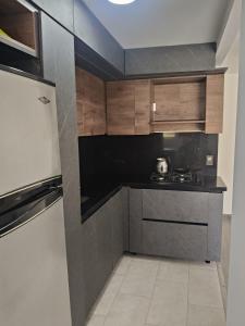 a small kitchen with a stove and a refrigerator at Confortable Apartamento cerca Aeropuerto JMC unidad Cerrada in Rionegro